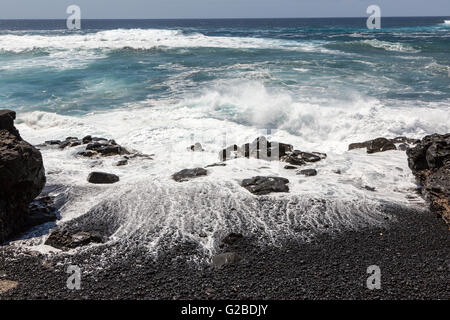 Wellen brechen sich am schwarzen vulkanischen Felsen am Strand, Playa Janubio, Lanzarote, Kanarische Inseln, Spanien Stockfoto