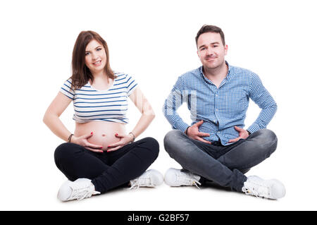 Brautpaar mit fröhlichen Mann stehen und Hand in Hand auf den Bauch seiner schwangeren Frau isoliert auf weiss Stockfoto