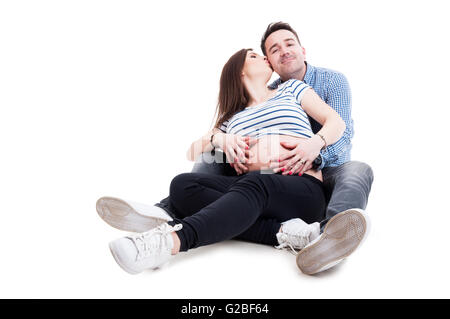 Schwangere Frau küssen ihr Ehemann während umarmen einander als Zärtlichkeit Konzept isoliert auf weiss mit Textfreiraum Stockfoto