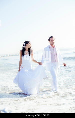 Braut und Bräutigam zu Fuß am Strand, Ibiza, Spanien Stockfoto