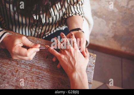 Künstler, die Erstellung von traditionellen Henna Malerei Mehndi auf weibliche Hände Stockfoto