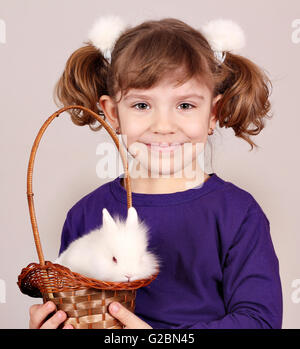 kleines Mädchen hält einen Korb mit weißen Zwerg Hase Stockfoto