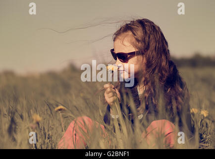 Mode Kinder Mädchen sitzen auf dem Rasen in Sonnenbrille auf Sommer Hintergrund Stockfoto