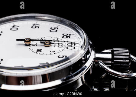 Chronometer auf Reflexion auf schwarzem Hintergrund isoliert Stockfoto