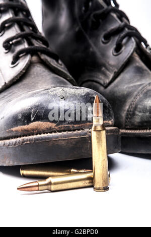 Kugeln und Armee Stiefel isolierten auf weißen Hintergrund mit Schatten Stockfoto