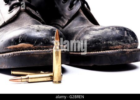 Armeestiefel und Kugeln isoliert auf weißem Hintergrund mit Schatten Stockfoto