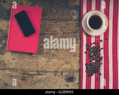 Overhead Schuss von Kaffee-Konzept mit Tasse, Geschirrtuch, ein Buch und ein smart phone Stockfoto