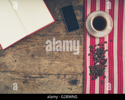 Overhead Schuss von Kaffee-Konzept mit Tasse, Geschirrtuch, ein offenes Buch und ein smart phone Stockfoto