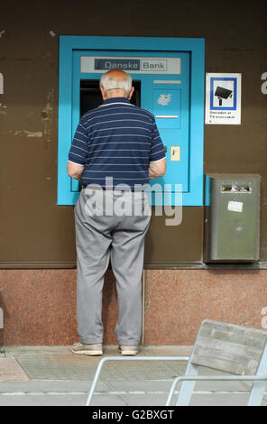Mann an einem ATM Geldautomaten Stockfoto