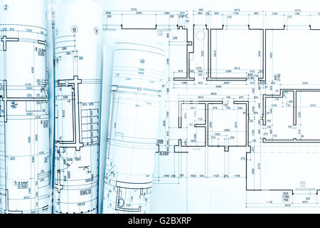 Rollen von architektonischen Pläne und technische Zeichnungen auf Schreibtisch Stockfoto