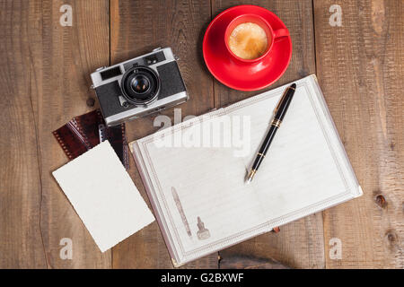 Alte Kamera mit Kaffee Alter Film und Foto auf Holz Hintergrund Stockfoto