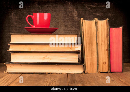 Alte Bücher auf Holztisch mit roten Kaffee-Haferl Stockfoto