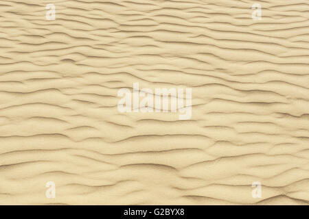 Eine Textur mit kristallklarem Sand mit Wellen. Stockfoto