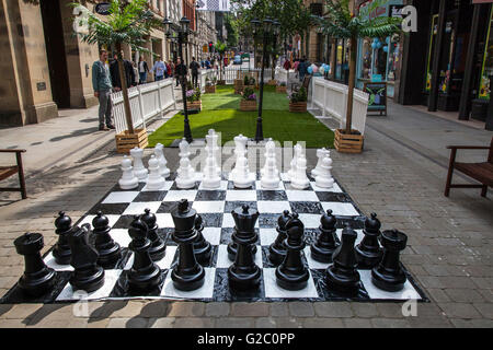 Riesenschach, Vorstand, Freizeit, spielen, set, Schachbrett, Wettbewerb, Spiel, weiß, groß, Schwarz, Intelligenz, Stück, Königin, Strategie, Bauer, Park, bewegen, Ritter, König, Outdoor, Kampf, Konzept, groß, Objekte, Abbildung: Eine Gruppe von Stücken, die am Frühjahrsfeiertag im zentralen Geschäftsviertel von Manchester im Mai stattfinden. Stockfoto