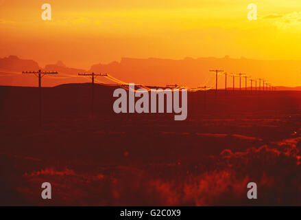 TELEFON & STROMLEITUNGEN BEI SONNENUNTERGANG IN SÜD-UTAH; USA Stockfoto