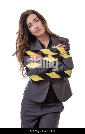 Geschäftsfrau, eingehüllt in gelben und schwarzen Klebeband isoliert auf weiss Stockfoto