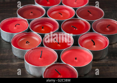 Viele kleine rote Kerzen Closeup auf Holztisch erloschen Stockfoto