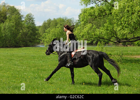 Fröhliche Cowgirl und galoppierenden Pferd Stockfoto