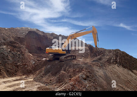 Bagger war Boden arbeiten und Bau Damm für die Aufbewahrung von Wasser, blauer Himmelshintergrund Graben. Stockfoto