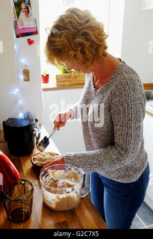 Frau macht hausgemachte Makrele Pastete in Küche mit Mixer Mixer Stockfoto