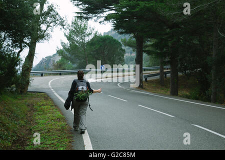 Hitch Wandern Frau, in einer Straße in den Wald zu Fuß Stockfoto