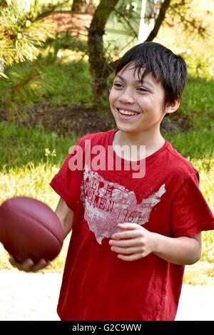 Ein kleiner Junge spielt Fußball in einem Feld Stockfoto