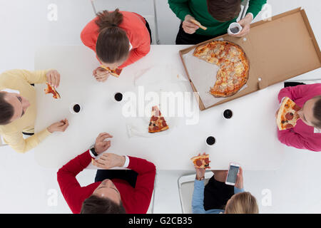 Draufsicht der Menschen rund um den Tisch sitzen und Essen pizza Stockfoto