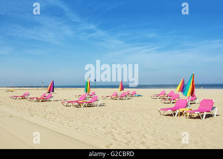 Leere Liegestühle am Strand und geschlossene Regenschirme. Stockfoto