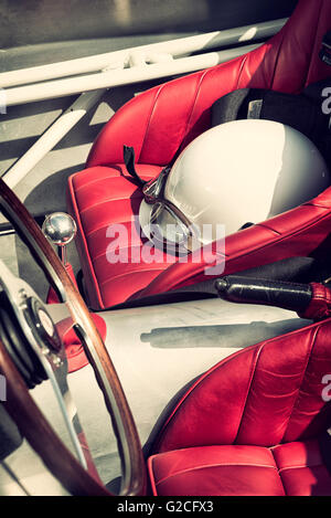 Vintage Helm und Schutzbrille in einem Maserati Barchetta 1953 Replica Auto in Brooklands, Weybridge, Surrey, England. Vintage Filter angewendet Stockfoto