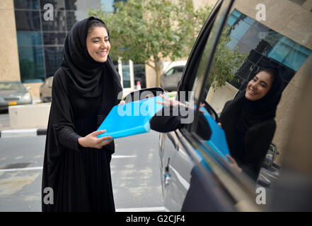 Emirati arabischen Geschäftsfrauen einsteigen in das Auto in Dubai, Vereinigte Arabische Emirate. Stockfoto