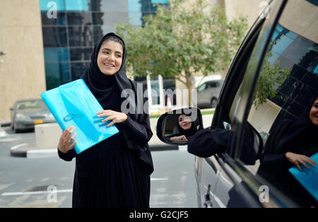 Emirati arabischen Geschäftsfrauen einsteigen in das Auto in Dubai, Vereinigte Arabische Emirate. Stockfoto