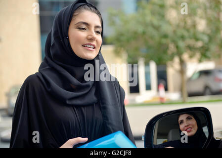 Emirati arabischen Geschäftsfrauen einsteigen in das Auto in Dubai, Vereinigte Arabische Emirate. Stockfoto