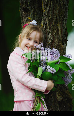 kleines Mädchen mit lila bouquet Stockfoto