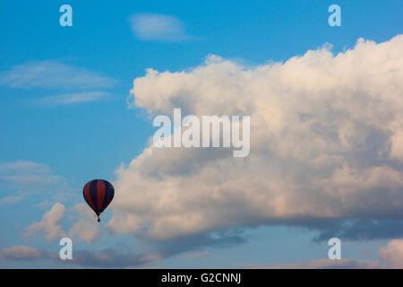 Einsamer Luft Ballon vor weißen geschwollenen Wolken fliegen Stockfoto