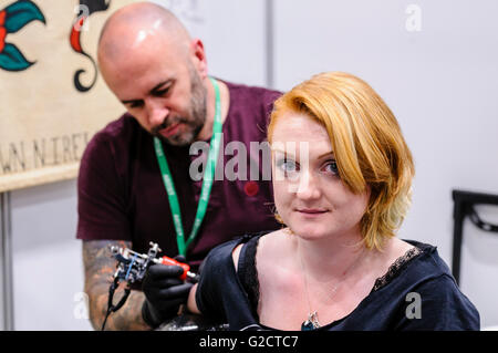 BELFAST, NORDIRLAND. 28. MAI 2016 - Nordirische Tattoo-Konferenz 6. Eine Kundin hat ein Tattoo auf ihrem Oberarm Stockfoto