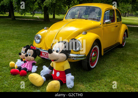 Gelbe VW Käfer und Mickey Maus Spielzeug Familie, Auto Spielzeug Stockfoto