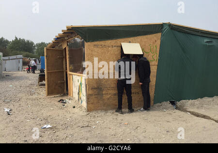 Calais, Frankreich. 27. Mai 2016. Zwei Männer suchen in einer provisorischen Hütte im Migranten Lager genannt "Dschungel" am Stadtrand von Calais, Frankreich, 27. Mai 2016. 40 verletzte Kommunen, sagte in einer Schlägerei auf dem Flüchtlingslager. Mehrere Unterstände wurden niedergebrannt. Foto: Anna Psaroudakis/Dpa/Alamy Live News Stockfoto