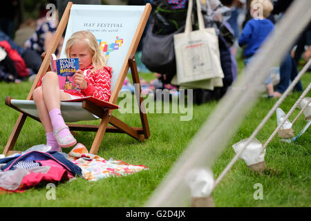Hay Festival 2016 - Mai 2016 - Ein junges Mädchen sitzt und liest Matilda von Roald Dahl auf dem Festival rasen. In diesem Jahr wird der 100. Jahrestag der berühmten Autor, seine Bücher bleiben beliebt wie eh und je. Foto Steven Mai/Alamy leben Nachrichten Stockfoto