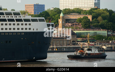 Hamburg, Deutschland. 27. Mai 2016. Das Kreuzfahrtschiff "Queen Mary 2" auf der Werft Blohm Voss docks und übergibt Zuschauer stehen auf dem Pier in Hamburg, Deutschland, 27. Mai 2016. Modernisierung und Reparaturarbeiten in der Werft beginnt und dauert bis 17. Juni 2016. Foto: DANIEL BOCKWOLDT/Dpa/Alamy Live News Stockfoto