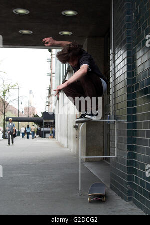 Springende Skater machen Tricks auf Bürgersteig Stockfoto