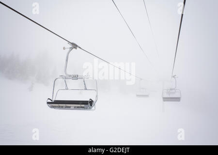 Ski-Sesselbahnen und Kabel im Nebel Stockfoto