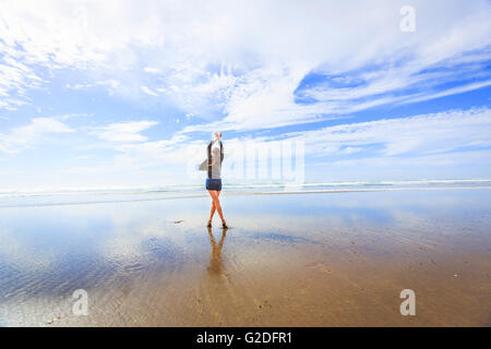 Junge Frau am Strand tanzen Stockfoto