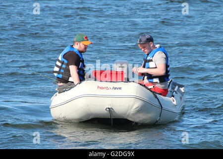 Drei Fischer tun ein Ort von Hochseeangeln auf den Firth of Clyde, von einem Honda Honwave Schlauchboot. Stockfoto