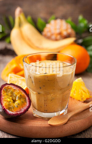 Smoothie mit tropischen Früchten: Mango, Passionsfrucht, Banane, Ananas im Weckglas Mason auf dem alten hölzernen Hintergrund Stockfoto