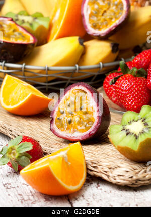 in Scheiben geschnittene Passionsfrucht und tropische Früchte im Sortiment: Bananen, Kiwi, Erdbeere, Mango, Ananas Stockfoto