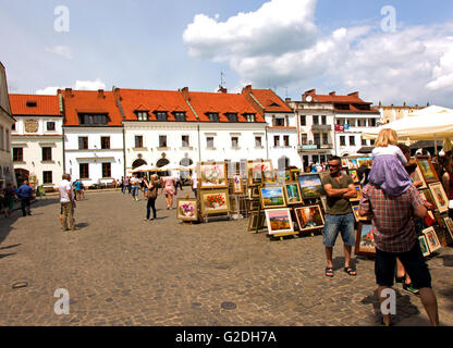 Ausstellung von Gemälden von Künstlern auf dem Markt in Kazimierz Dolny in Polen und Touristen zu Fuß auf dem Markt. Editoria Stockfoto