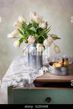 Stilleben mit Tulpen in alten Milch kann und Birnen Stockfoto