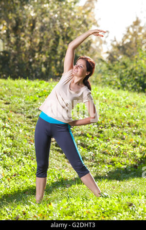 Frau, trainieren im Park auf dem grünen Rasen Stockfoto