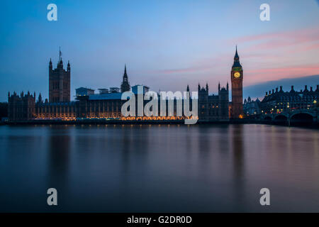 Palast von Westminster in London und dem Big Ben in der Nacht mit Fahrzeug hinterließ eine Schneise entlang der Straße, mit einem klaren blauen Himmel. Stockfoto