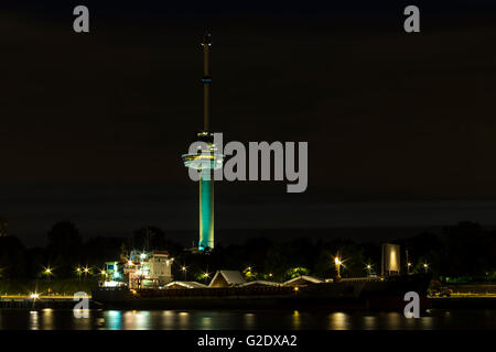 Der Euromast Tower Rotterdam in der Nacht. Ein großes Schiff und Kanal im Vordergrund, der Turm wird nach Einbruch der Dunkelheit beleuchtet Stockfoto